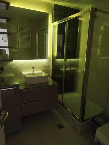 a bathroom with a sink and a glass shower at Skopje Sky Apartments & Floor 33th 28th & 25th & 19th & 13th 12th With Pool & Spa & Fitness & Parking Included in Price in Skopje