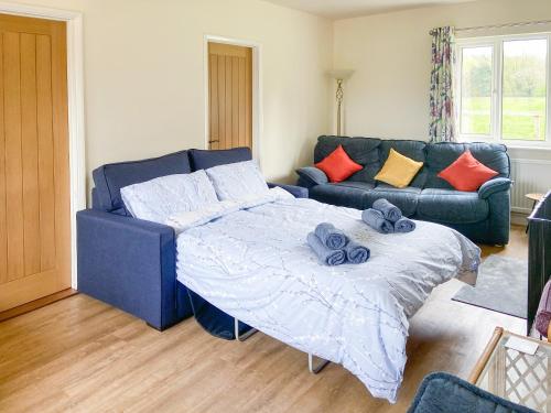 a living room with a bed and a couch at Old Alton Hall Farmhouse in Tattingstone