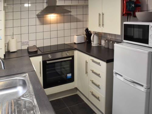 a kitchen with a sink and a stove top oven at Beach Happy in Great Yarmouth