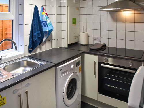 a kitchen with a washing machine and a sink at Beach Happy in Great Yarmouth