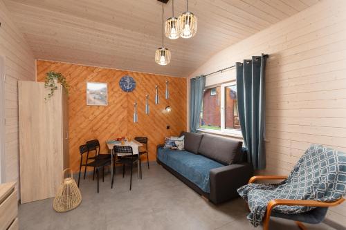 a living room with a couch and a table at Domki Leśny Zakątek in Pogorzelica