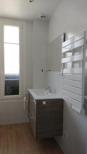 une salle de bain blanche avec un lavabo et une fenêtre dans l'établissement 3P Appart, 10' from Palais Festival Cannes, au Cannet