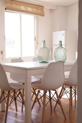 a dining room table with three glass vases on it at La casita del tío tomas in Montanejos