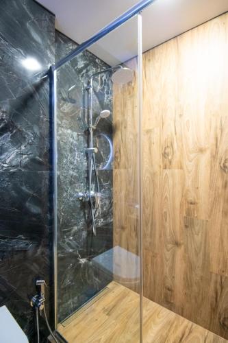 a shower in a bathroom with wooden walls at Go-Gudauri The Atrium Residence in Gudauri