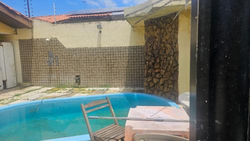 a swimming pool with a chair next to a house at Península Centro histórico e praias quartos e suítes in São Luís