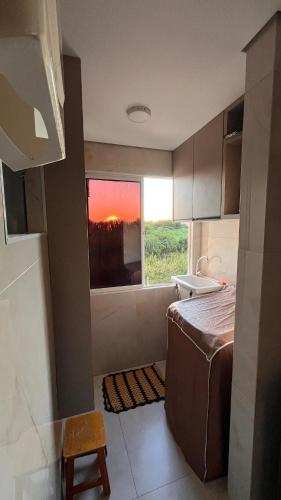 a bathroom with a bed and a window and a sink at Apartamento Moderno & Mobiliado - Próximo ao Aeroporto, Condomínio Village Natureza in Juazeiro do Norte
