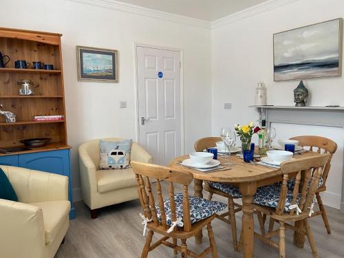 a kitchen and dining room with a wooden table and chairs at Smile 'N' Wave in Gorleston-on-Sea