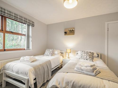 a bedroom with two beds and a window at Rowan Muir in Springside