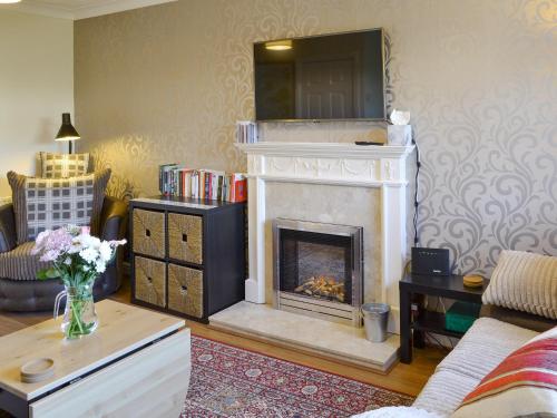 a living room with a fireplace with a tv above it at Signals Court in Scarborough