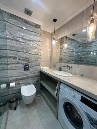 a bathroom with a washing machine and a sink at Go-Gudauri The Atrium Residence in Gudauri