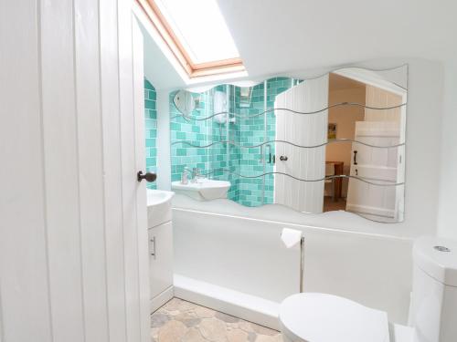 a bathroom with a white tub and a sink at Broom Cottage in East Rudham