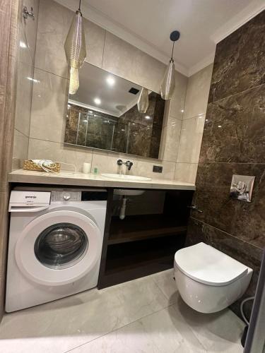 a bathroom with a washing machine and a sink at Go-Gudauri The Atrium Residence in Gudauri