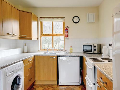 a kitchen with a white dishwasher and a microwave at Moy in Taynish