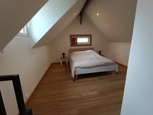une chambre avec un lit dans un grenier dans l'établissement Studio en duplex 24H du Mans, à Étival-lès-Le Mans
