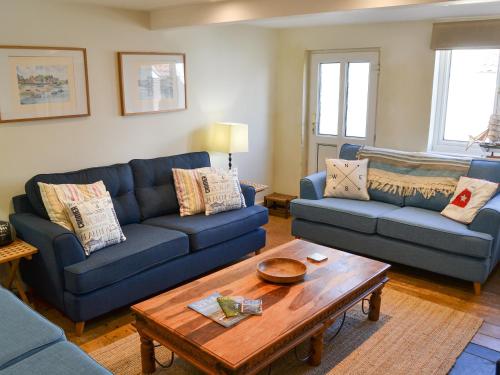 a living room with two blue couches and a coffee table at Jicklings in Wells next the Sea