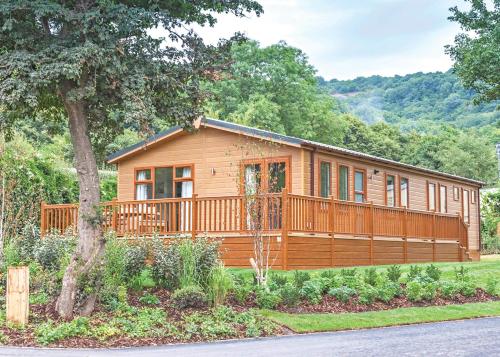 a large wooden cabin with a large deck at Cheddar Woods Resort And Spa in Cheddar
