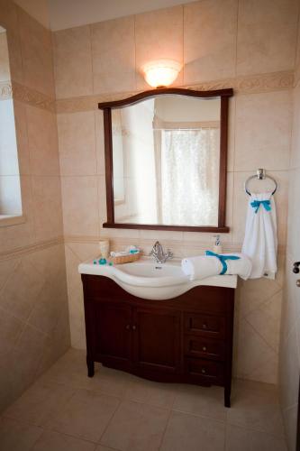 a bathroom with a sink and a mirror at Villa-Aristotelis in Gerani