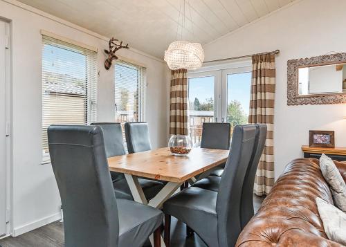a dining room with a table and chairs and a couch at Cheddar Woods Resort And Spa in Cheddar
