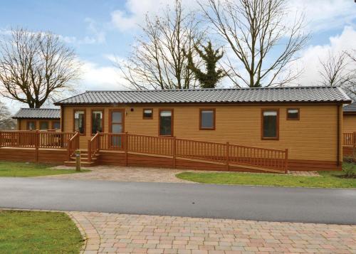a large wooden house with a large deck at Cheddar Woods Resort And Spa in Cheddar