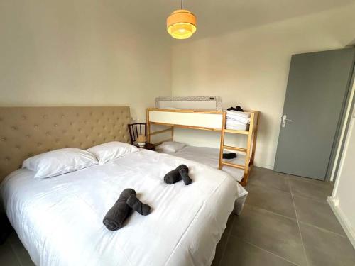 une chambre avec un lit avec deux chaussures dessus dans l'établissement Valras'Loc - Le Nid Familial, à Valras-Plage
