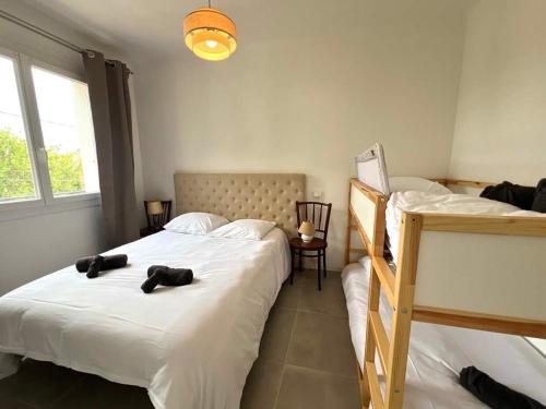 - une chambre avec 2 lits jumeaux et une lampe dans l'établissement Valras'Loc - Le Nid Familial, à Valras-Plage