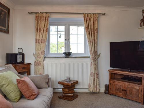 a living room with a couch and a television at Barn House in Settle