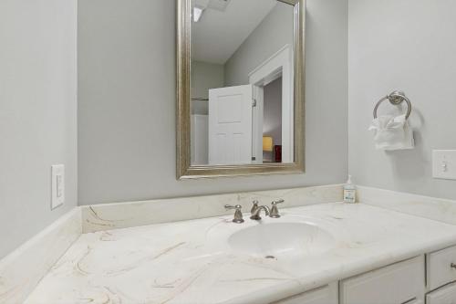 a white bathroom with a sink and a mirror at Cinzia Lane Bungalow in Myrtle Beach