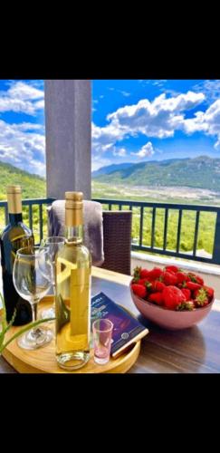 a bottle of wine and a bowl of fruit on a table at Kika in Vrgorac