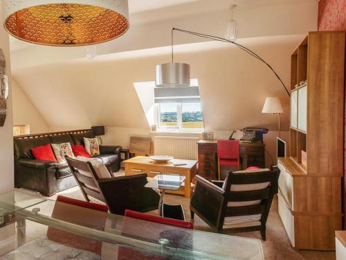 a living room with a glass table and chairs at Apartment Hole 18 34 in Nailsworth