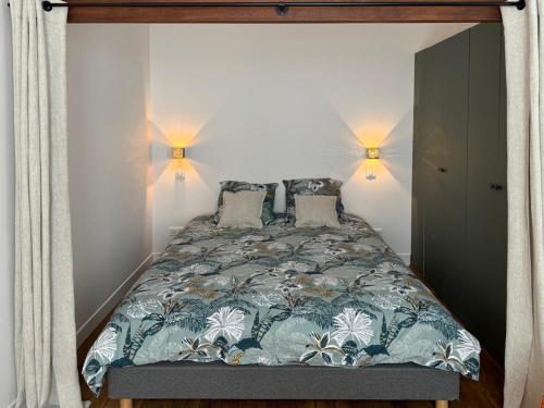 une chambre avec un lit avec deux lampes dessus dans l'établissement Cocon lumineux au coeur du 18ème, à Paris