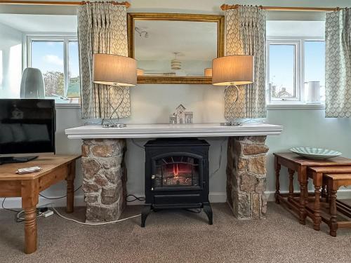 a living room with a fireplace with a mirror at Cherry Tree Cottage - Uk46659 in Cheddar
