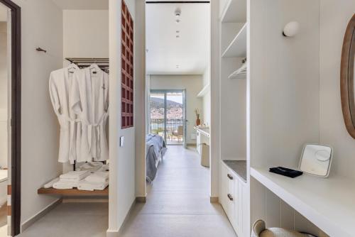 a hallway with a dressing room and a bedroom at Minnŏ Boutique Hotel & Spa in Skopelos Town