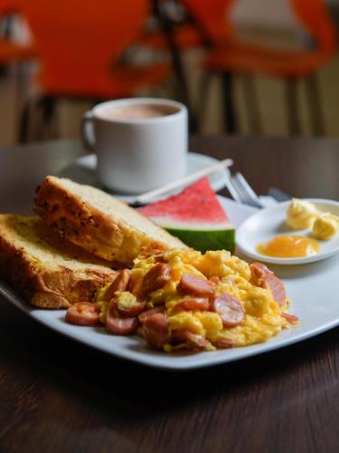 a plate of scrambled eggs and toast and a cup of coffee at Hotel Avanty in Ipiales