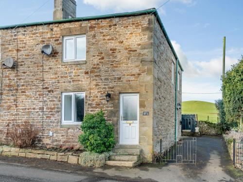 a brick house with a white door at South View in Haydon Bridge