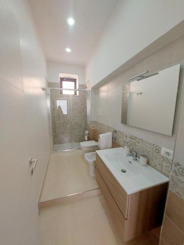 a bathroom with a sink and a toilet and a mirror at Modestina's house in Mondragone