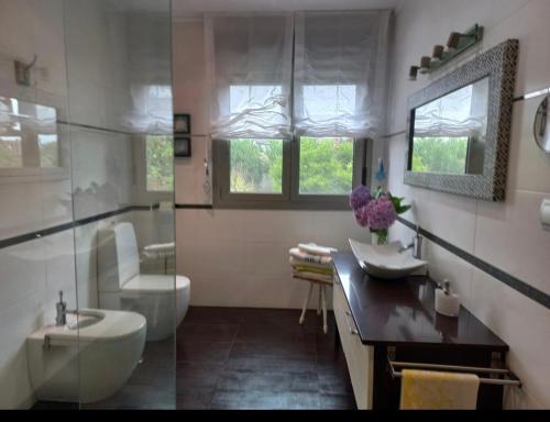 a bathroom with a tub and a sink and a toilet at Habitación en casa moderna con jardín in Santa Cruz de Bezana