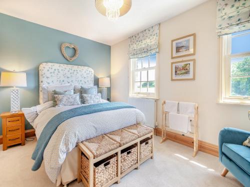 a bedroom with a bed with a blue bedspread at Farrington House in Lowthorpe