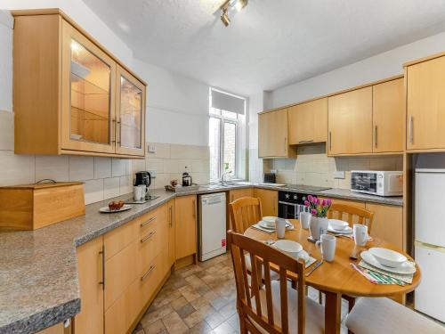 a kitchen with a wooden table with chairs and a dining room at Cherry Blossom in Skegness