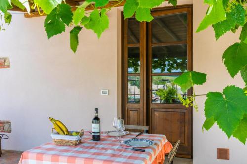 a table with a bowl of bananas and a bottle of wine at Podere La Querciola in Guardistallo