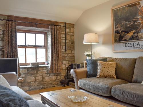 a living room with a couch and a table at The Cottage At Wilson House in Rokeby
