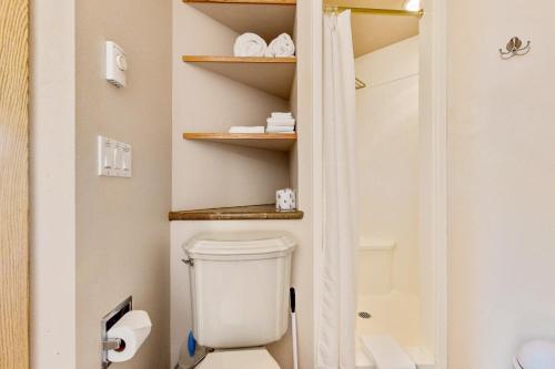 a bathroom with a toilet and shelves at Mercer Lake Memories in Florence