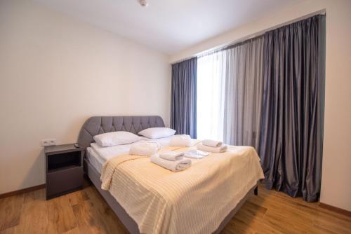 a bedroom with a bed with towels on it at Go-Gudauri The Atrium Residence in Gudauri