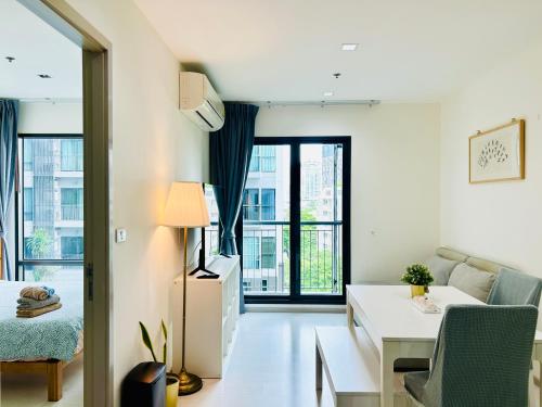 a white living room with a desk and a couch at Luxury Two bedrooms Thonglor in Bangkok