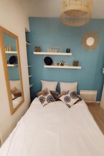- une chambre avec un lit blanc et des oreillers dans l'établissement Studio cosy Paris Centre, à Paris
