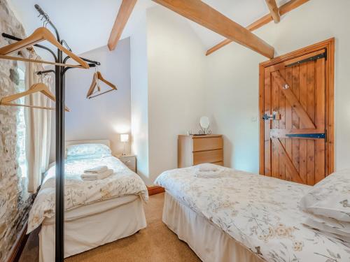 a twin bedroom with two beds and a door at Lord Mayors Barn in Alston