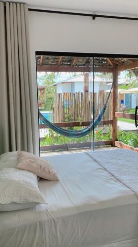 a bed with a hammock in front of a window at POUSADA CAJU DO MATO in Prado