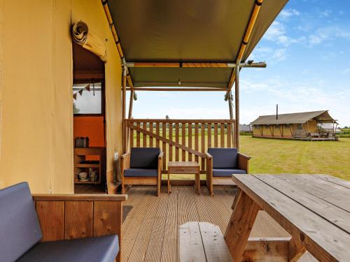 a porch with a wooden table and chairs and a wooden table at Fallow - Uk47397 in Bawdeswell