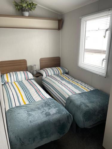 a room with two beds and a window at J4 Lossiemouth Bay Caravan Park in Lossiemouth