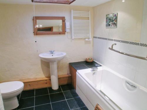 a bathroom with a sink and a tub and a toilet at Ty Christian in Blaencelyn