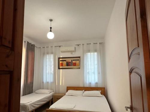 a bedroom with two beds and a window at Seid Apartments Radhime in Vlorë